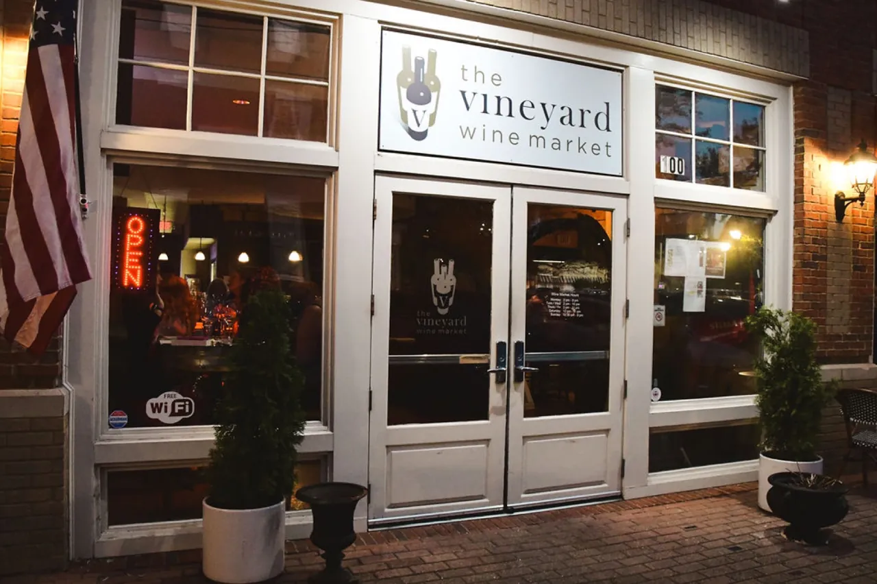 The front entrance of The Vineyard Wine Market, with its sign above the double glass doors