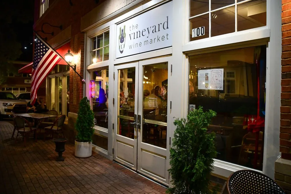 The Vineyard Wine Market storefront at night in Smyrna Market Village